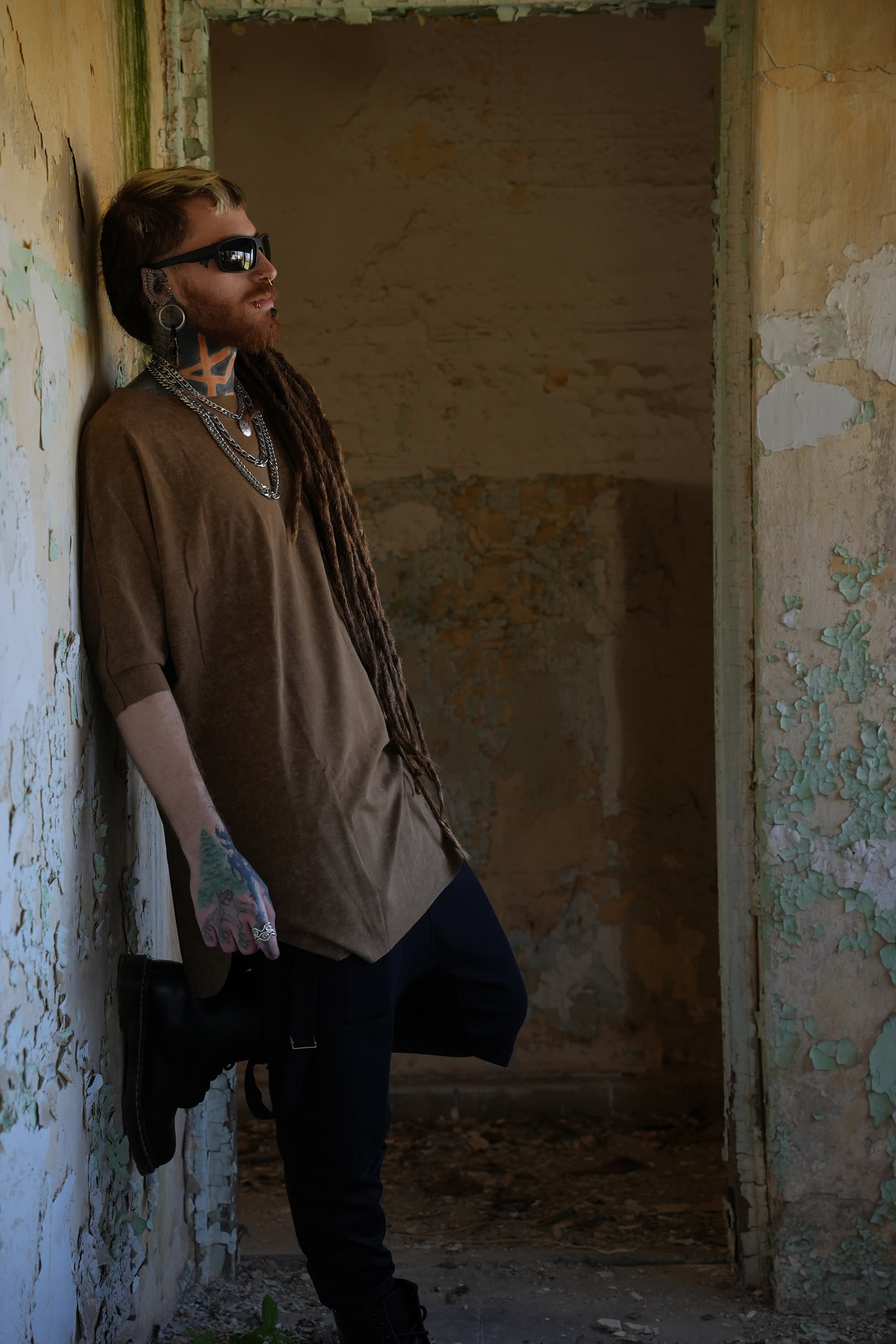 Uriel leaning against a weathered wall in an abandoned building